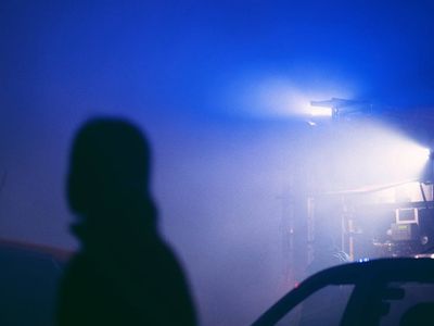 Silhouetted person stretching against a bright window background